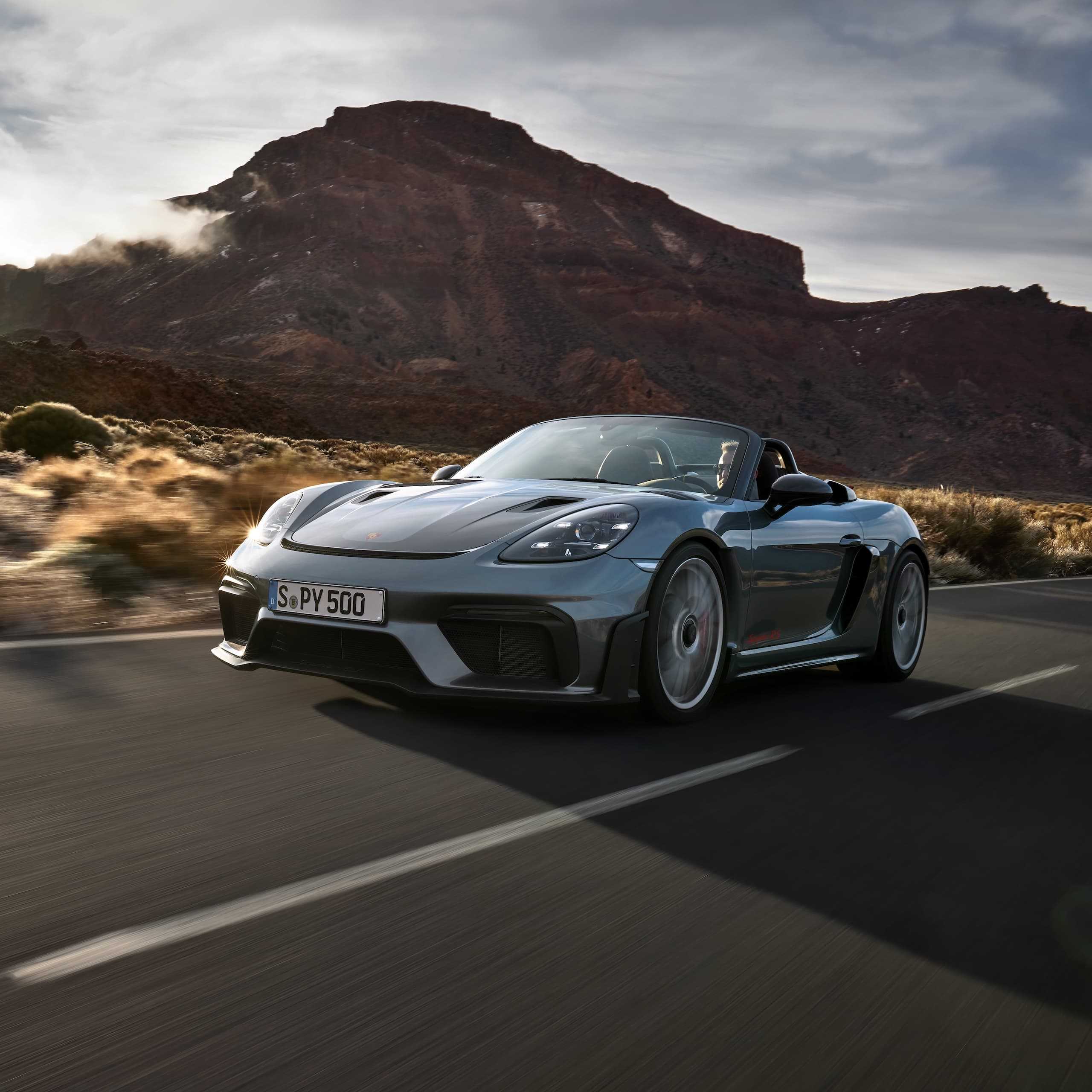 Porsche 718 Spyder RS fährt auf der Straße zwischen Felsformationen.